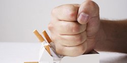 Man’s hand crushing pack of cigarettes