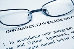 Dental insurance coverage paperwork with glasses on top