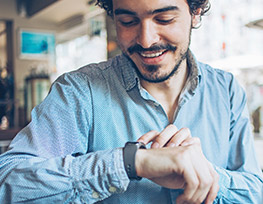 Smiling young man checking his watch