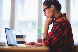 woman researching same day dental crowns on laptop