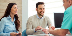 dentist and couple talking in dental office