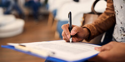 woman filling out insurance form in lobby
