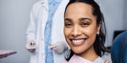 woman smiling while sitting in dentist treatment chair