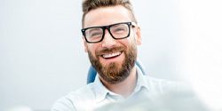 : a man smiling after receiving his dental crown