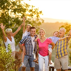 Happy family smiling outdoors after family dentistry