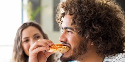 person eating food with their friend sitting next to them