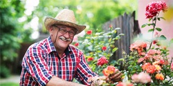 person pruning flowers outside and smiling