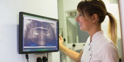 dental assistant looking at a patient X rays 