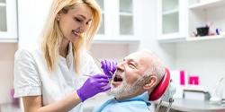 A dentist determining a dental patient's candidacy for dental implant dentures