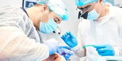 Two dentists performing dental implant denture process