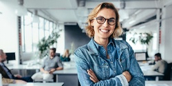 A woman smiling after dental implant supported denture restoration