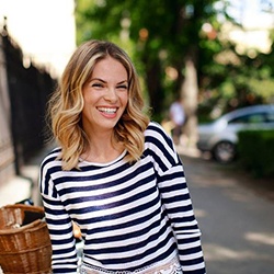 woman smiling outside after dental implant tooth replacement