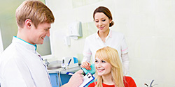 Woman in dental chair talking to dentist