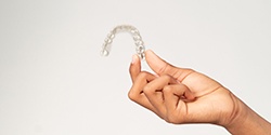 Closeup of teen holding clear aligner