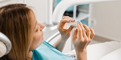 Patient holding clear aligner in treatment room