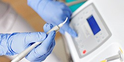 Gloved hands preparing to use dental laser