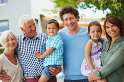 Three generations of family smiling outdoors