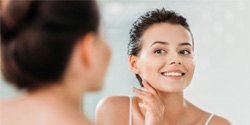 Woman in front of mirror, smiling at herself