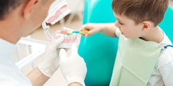Child practicing tooth brushing during children's dentistry visit
