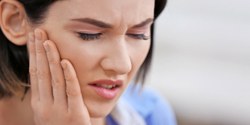 Woman with tooth pain before root canal therapy