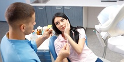 Woman holding cheek in pain before root canal therapy