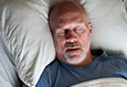 man sleeping peacefully thanks to sleep apnea therapy
