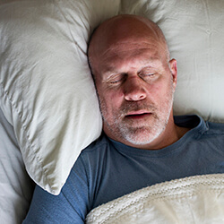 man sleeping soundly thanks to sleep apnea therapy