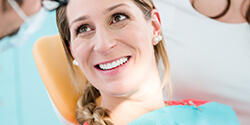 woman in chair smiling after soft tissue laser dentistry