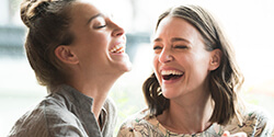 Two woman with tooth colored fillings laughing