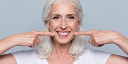 Woman pointing to her smile after teeth whitening