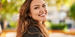 Closeup of woman with white teeth smiling outside