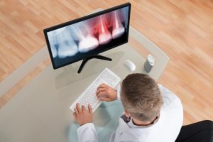 A dentist working on a computer.