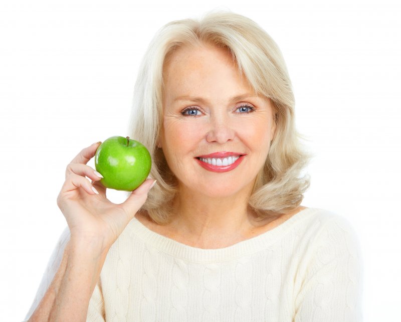 older woman blonde hair holding apple 