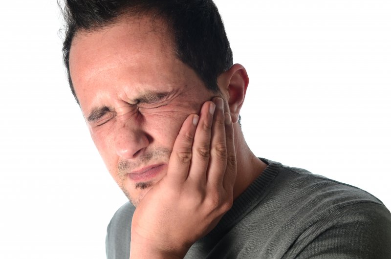 woman on phone with jaw pain