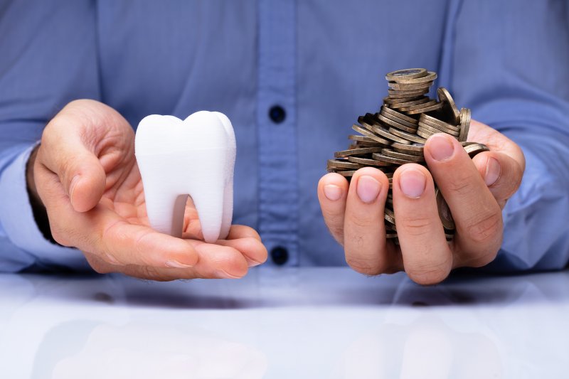 man holding tooth and coins