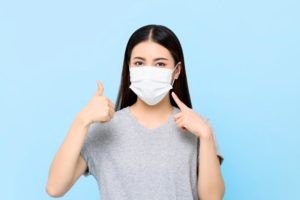 young woman wearing face mask to visit dentist 