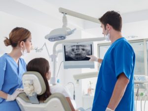 dentist showing patient their x-rays during consultation for dental implants 