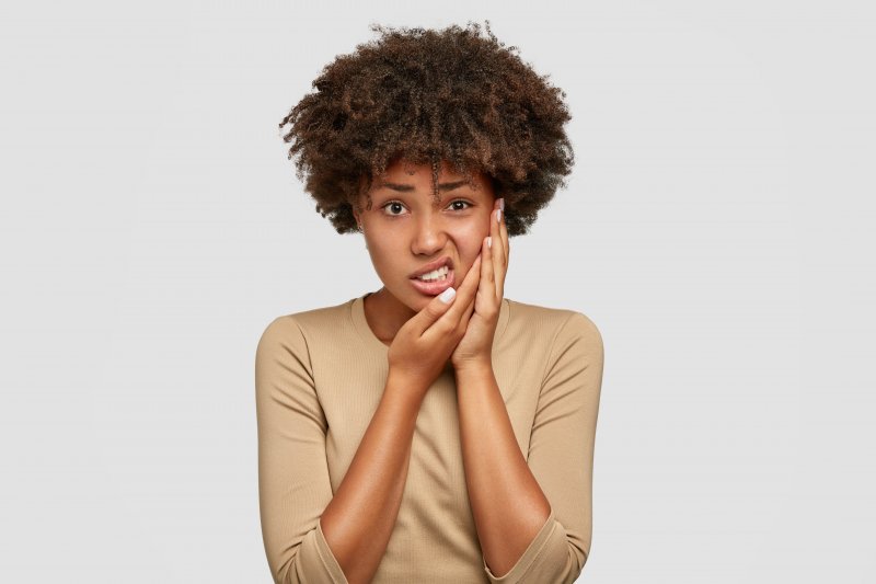 Patient holding their cheek in pain