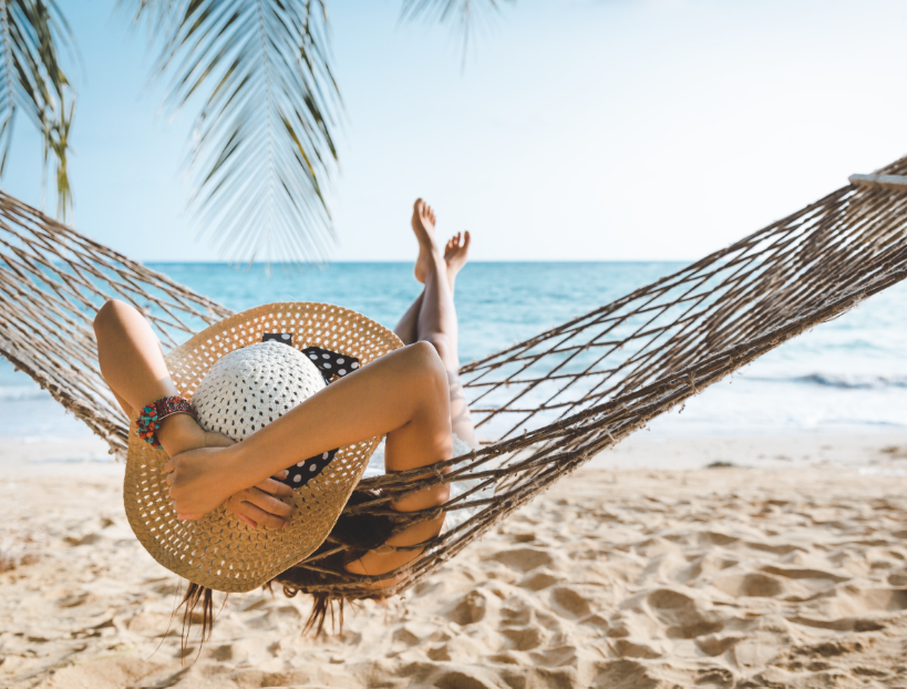 Woman at beach in hammock wearing sun hat